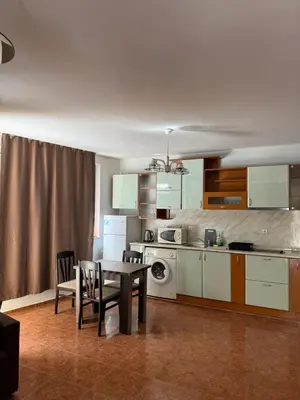 a kitchen with a table and chairs in a room at Апартамент Александър in Sunny Beach