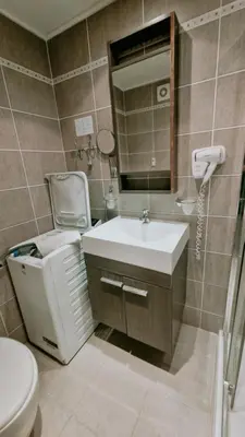 a bathroom with a sink and a toilet and a mirror at Апартаменти Бяла Бийч - Apartments Byala Beach in Byala