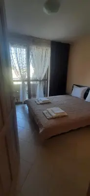 a bedroom with a bed and a window with curtains at Kalia Sunny Beach 1 bedroom apartment in Sunny Beach