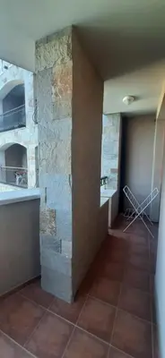 a room with a stone wall and a tile floor at Kalia Sunny Beach 1 bedroom apartment in Sunny Beach