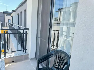 a black chair sitting on the balcony of a building at Saltwater Escape in Sozopol in Sozopol