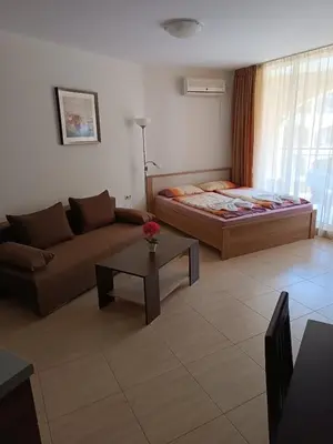 a living room with a couch and a bed at MIDIA Family Resort - studio s výhledem na moře in Aheloy