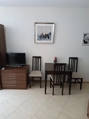 a dining room with a table and chairs and a tv at MIDIA Family Resort - studio s výhledem na moře in Aheloy