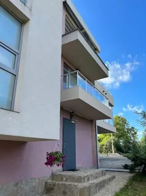 a building with a blue door and a balcony at Sunny house in Pismenovo