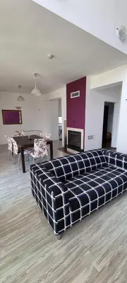 a large couch in a living room with a table at Sunny house in Pismenovo