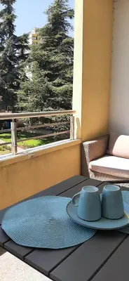 a table with a plate and two cups on a balcony at Sea Apartament Kristal Beach,Nessebar in Nesebar