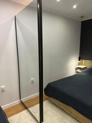 a bedroom with a black bed and a mirror at Casa Raffaelo in Burgas City