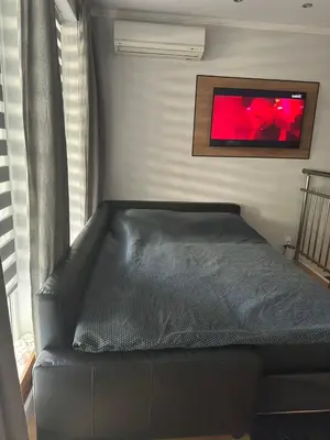 a black leather couch in a room with a painting at Casa Raffaelo in Burgas City