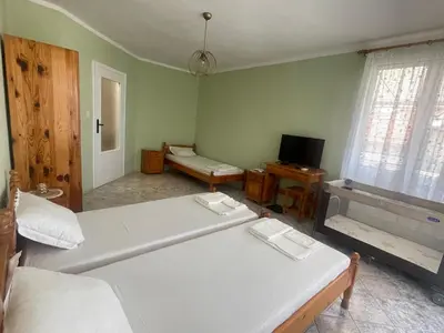 a bedroom with two white beds and a television at KudevApartment1 in Nesebar