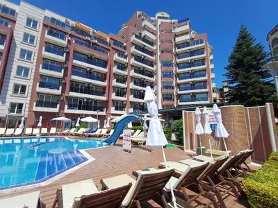 a hotel with a swimming pool with chairs and a slide at Admiral Plaza 35 -studio-Sunny Beach in Sunny Beach