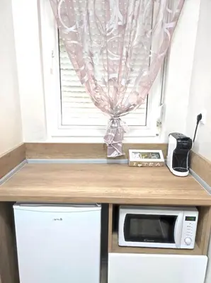 a kitchen with a microwave and a window at VN Home 2 in Pomorie
