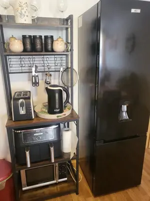 a black refrigerator in a kitchen next to a table at Vineyard luxery spa resort in Kableshkovo
