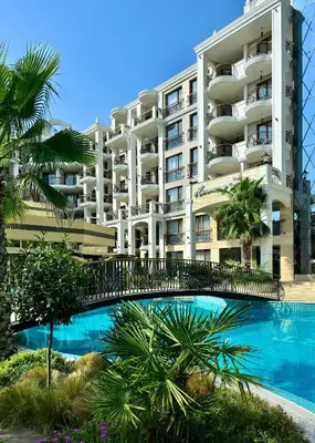 a large apartment building with a swimming pool and palm trees at Harmony Grand Resort - Apartament Gut in Sunny Beach