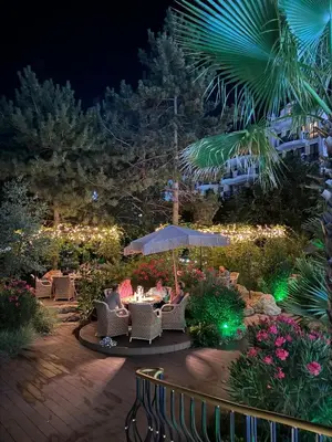 a patio with tables and chairs and lights at night at Harmony Grand Resort - Apartament Gut in Sunny Beach