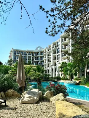 a large apartment building with a swimming pool and an umbrella at Harmony Grand Resort - Apartament Gut in Sunny Beach