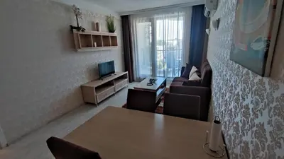 a living room with a table and a couch at Luxuriöse Ferienwohnung im Harmony Suites Monte Carlo in Sunny Beach