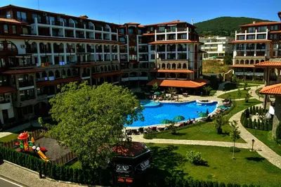 a resort with a large swimming pool in front of buildings at Olymp SkyView Apartment in Sveti Vlas