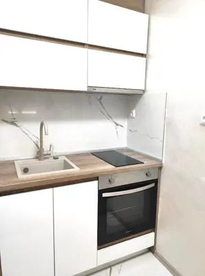 a kitchen with white cabinets and a sink at VN Home 1 in Pomorie