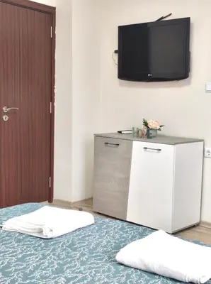 a room with a tv on the wall and two pillows at VN Home 1 in Pomorie