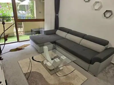 a living room with a couch and a glass table at Cascadas Family Resort apartment pool view in Sunny Beach
