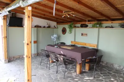 a dining room with a purple table and chairs at Къща за гости АВЛИГА in Varna City