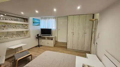 a living room with a table and a television at Къща за гости АВЛИГА in Varna City