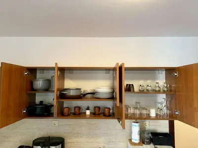 an open cabinet with dishes and other kitchen items at Прекрасно място за нощувки в Слънчев бряг in Sunny Beach
