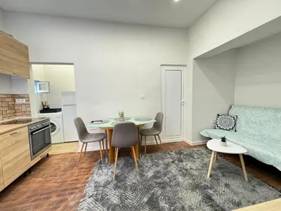a living room with a table and chairs and a kitchen at Apartment Compass- Super Center Burgas in Burgas City