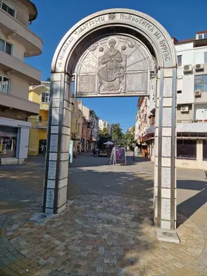 an archway with a statue in a city street at Apartment Compass- Super Center Burgas in Burgas City