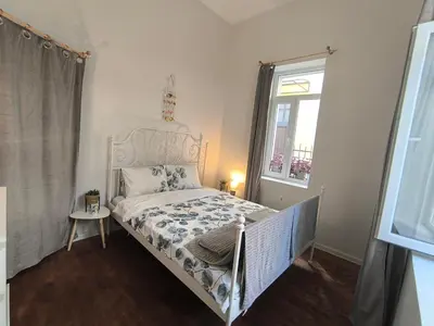 a small bedroom with a bed with a white bed frame at Apartment Compass- Super Center Burgas in Burgas City