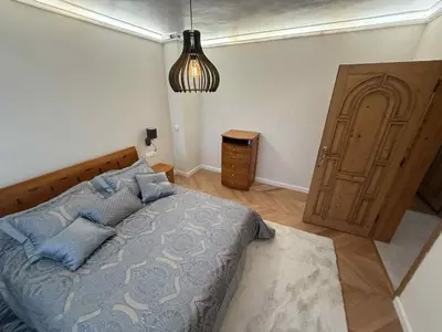 a bedroom with a bed and a wooden door at Victoria- две спални делукс до Морската градина и центъра in Burgas City