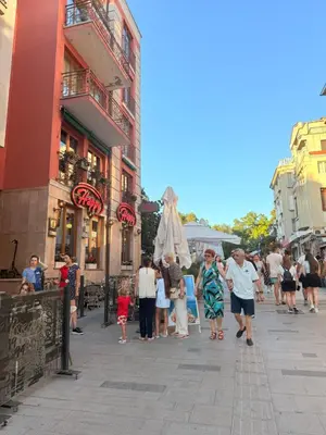 a group of people walking down a city street at Victoria- две спални делукс до Морската градина и центъра in Burgas City