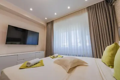 a hotel room with a bed and a television at Luxury Seaside Apartment in Varna City
