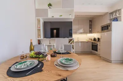 a kitchen with a wooden table with plates and wine glasses at Luxury Seaside Apartment in Varna City