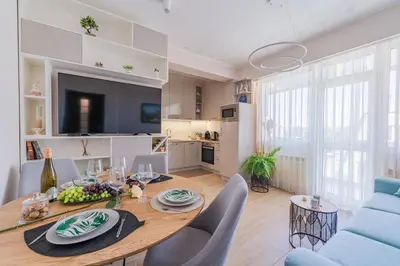 a dining room and living room with a table and chairs at Luxury Seaside Apartment in Varna City