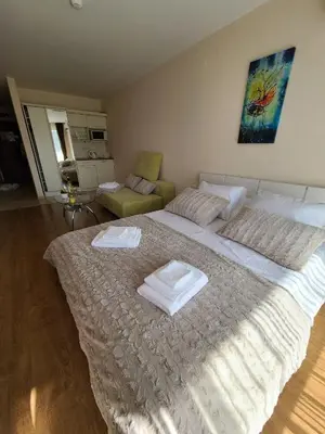 a large white bed with two towels on top of it at Privet apartament in Premier Fort in Sveti Vlas