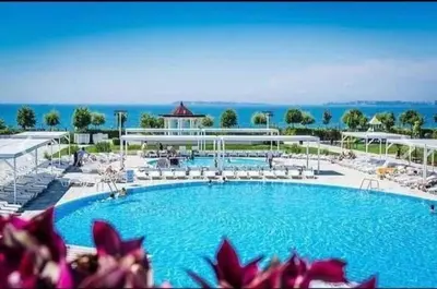 a large swimming pool with chairs and a building at Privet apartament in Premier Fort in Sveti Vlas