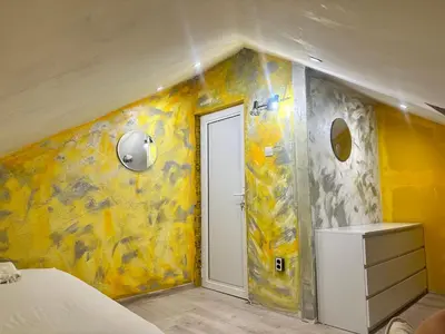 a bedroom with yellow walls and a white door at Мансарда in Nesebar