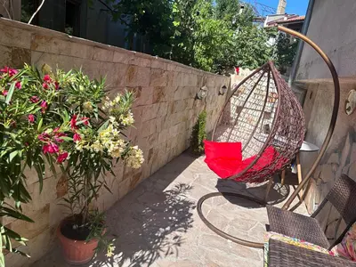 a hammock sitting on a patio next to some plants at Мансарда in Nesebar