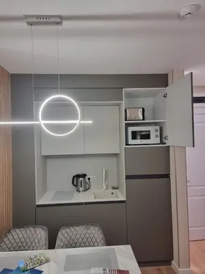 a kitchen with a table and a white kitchen at Harmony Suites 16 in Sunny Beach