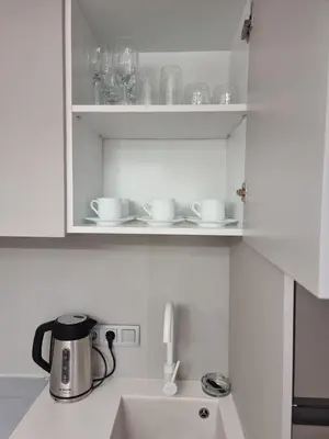 a kitchen counter with a tea pot and cups on a shelf at Harmony Suites 16 in Sunny Beach