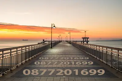 a pier stretches out into the ocean at sunset at LAZUR - Nice Sunny Flat in Burgas City