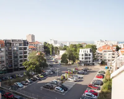 a city street with cars parked in a parking lot at LAZUR - Nice Sunny Flat in Burgas City