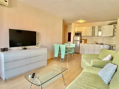 a living room with a couch and a tv at Prestige Fort Aparthotel - Private apartment - BSR - 1 in Sveti Vlas