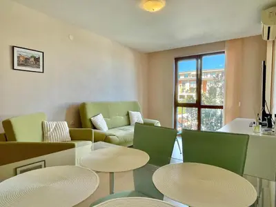 a living room with two tables and green chairs at Prestige Fort Aparthotel - Private apartment - BSR - 1 in Sveti Vlas