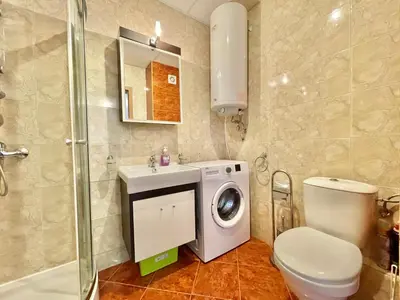 a bathroom with a washing machine and a toilet at Prestige Fort Aparthotel - Private apartment - BSR - 1 in Sveti Vlas