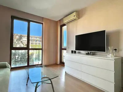 a living room with a flat screen tv on a dresser at Prestige Fort Aparthotel - Private apartment - BSR - 1 in Sveti Vlas