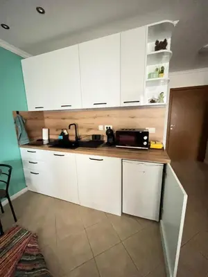 a kitchen with white cabinets and a microwave at Aquamarine Studio in Santa Marina in Sozopol
