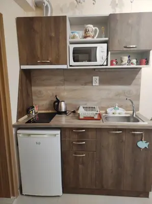 a small kitchen with a sink and a microwave at Студио в центъра на стария Несебър in Nesebar