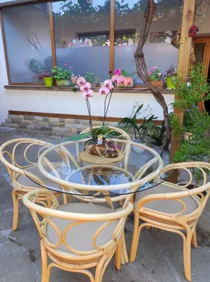 a glass table and chairs with flowers on it at Студио в центъра на стария Несебър in Nesebar